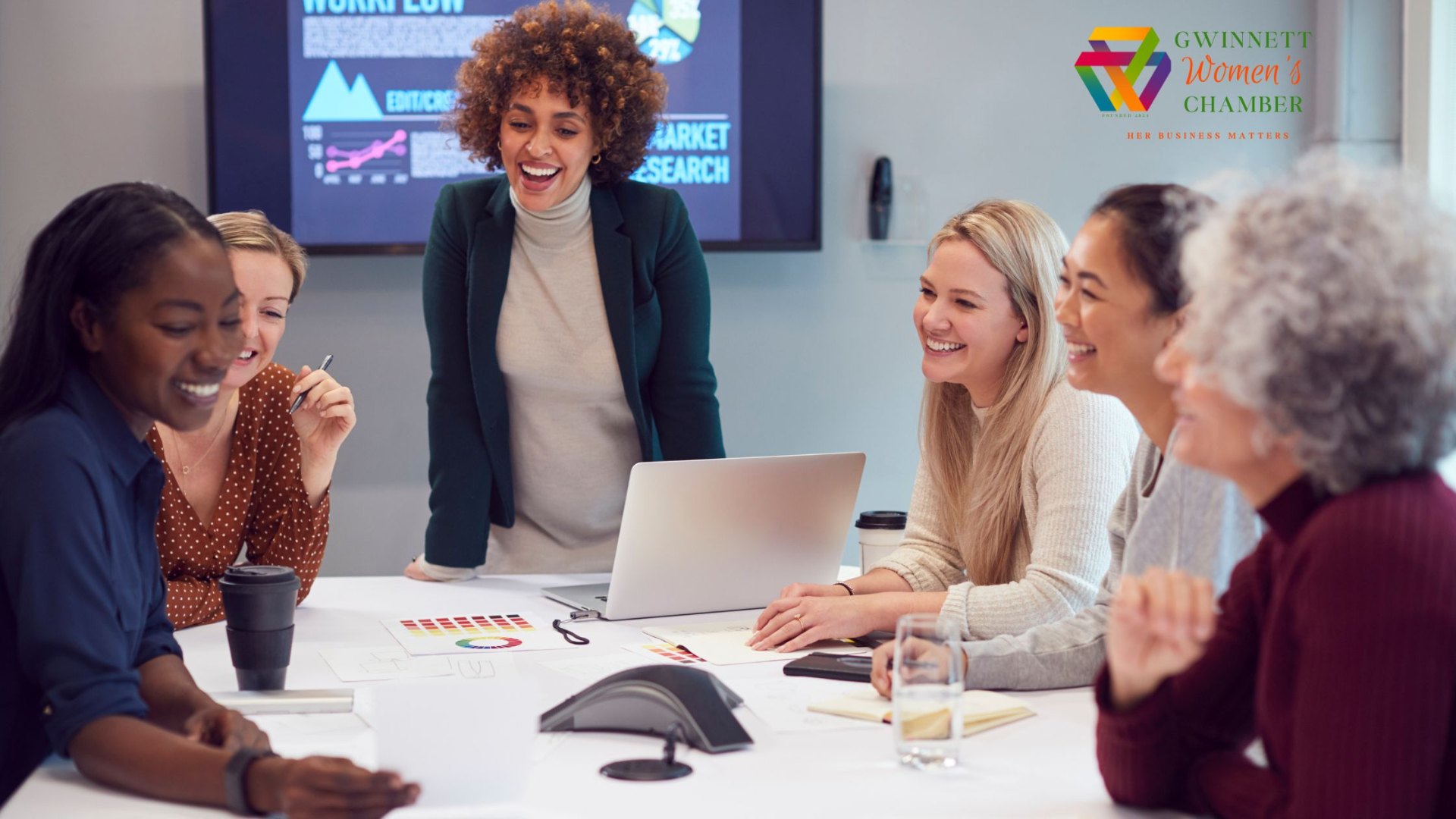 Diverse group of women in a business meeting smiling and collaborating